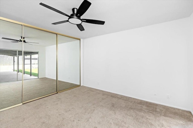 unfurnished bedroom with carpet flooring, a ceiling fan, baseboards, and a closet