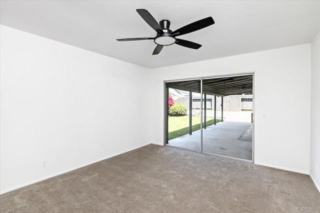 carpeted spare room featuring baseboards and ceiling fan