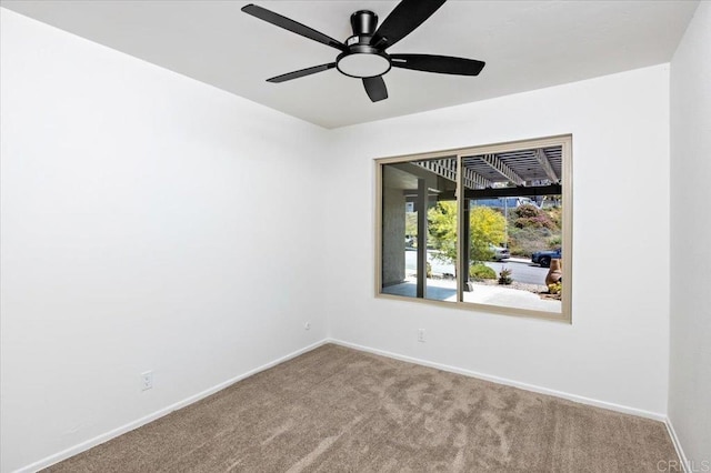 carpeted empty room featuring baseboards and ceiling fan