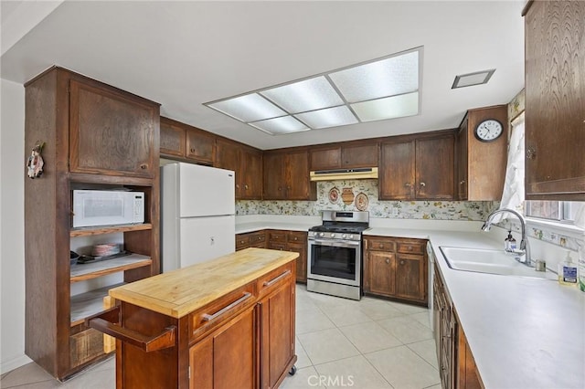23692 Cavanaugh Rd, Lake Forest, CA 92630 - kitchen with white appliances, a sink, under cabinet range hood, light tile patterned floors, and wooden counters