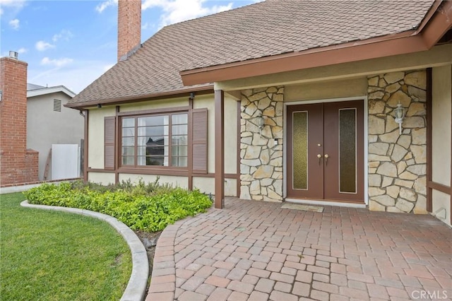 23692 Cavanaugh Rd, Lake Forest, CA 92630 - view of exterior entry with stone siding, roof with shingles, and a chimney