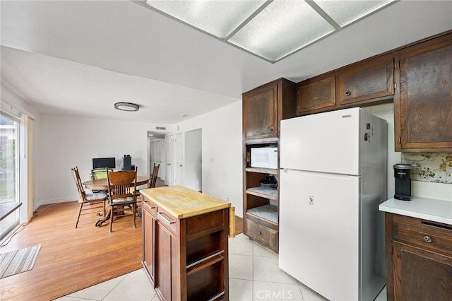 23692 Cavanaugh Rd, Lake Forest, CA 92630 - kitchen featuring white appliances, wood counters, dark brown cabinetry, light wood-style floors, and open shelves