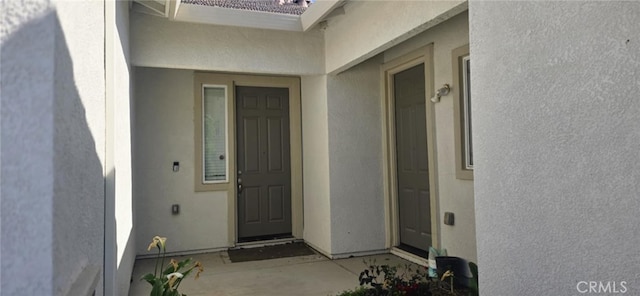 entrance to property featuring stucco siding