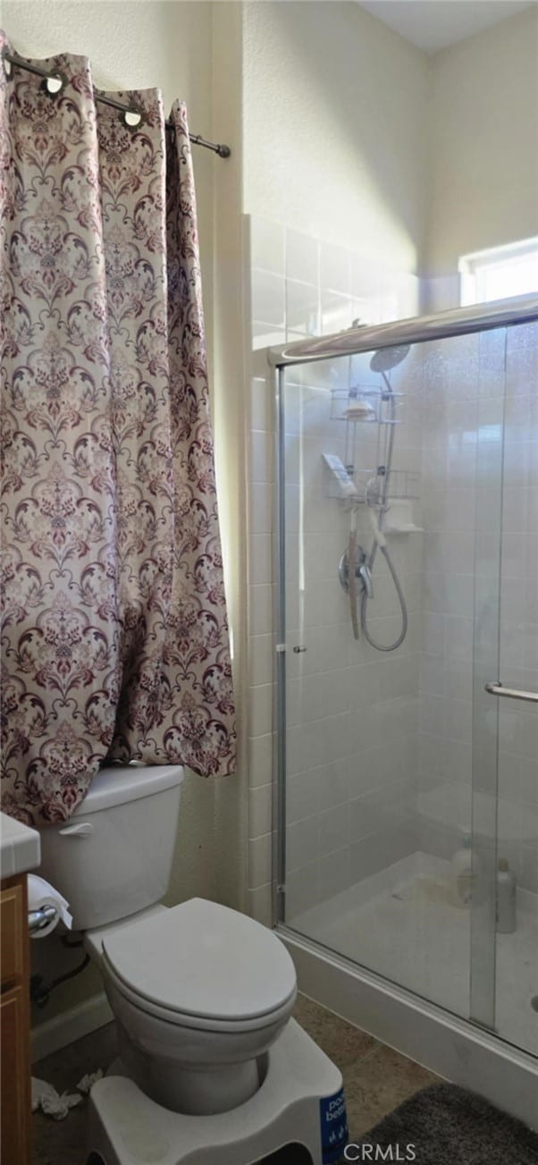 full bathroom featuring toilet, a shower stall, and vanity