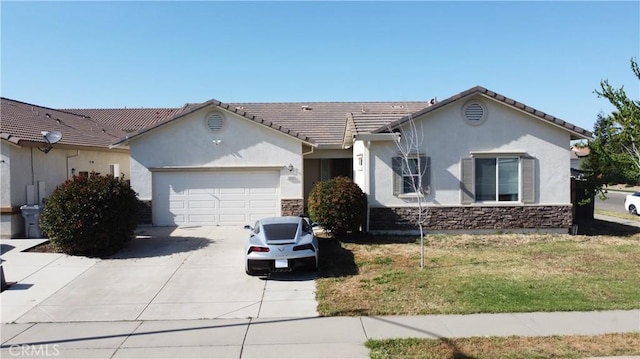 ranch-style home featuring an attached garage, stone siding, stucco siding, a front yard, and concrete driveway