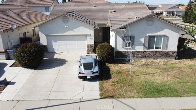 view of front of home featuring a garage, driveway, stone siding, and stucco siding