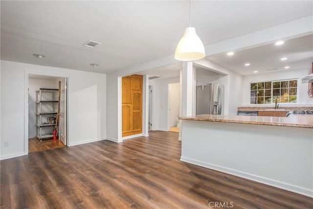 kitchen with gas cooktop, recessed lighting, baseboards, dark wood-type flooring, and stainless steel refrigerator with ice dispenser