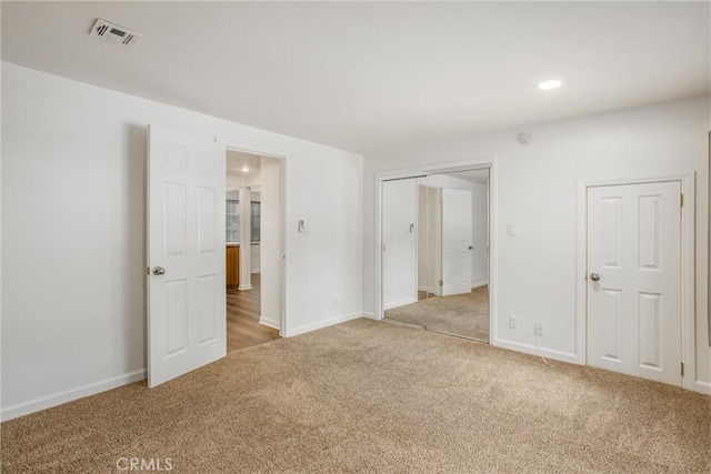 unfurnished bedroom with baseboards, visible vents, recessed lighting, and light colored carpet