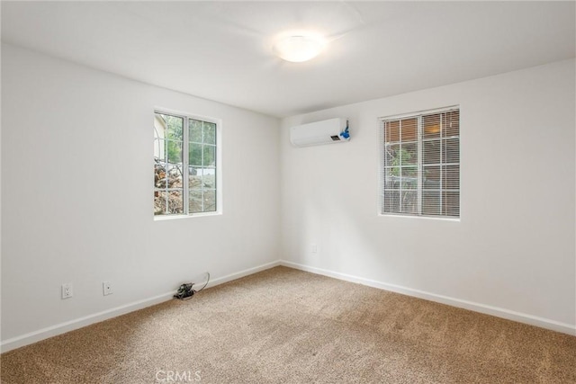 carpeted spare room with baseboards and a wall mounted AC