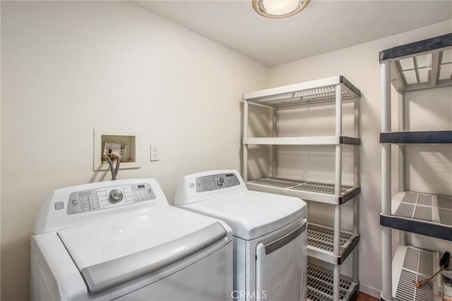 laundry area featuring laundry area, washing machine and dryer, and wood finished floors