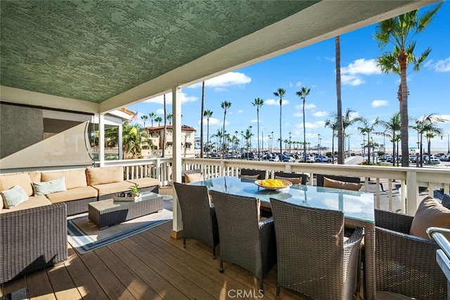wooden deck with an outdoor hangout area and outdoor dining space
