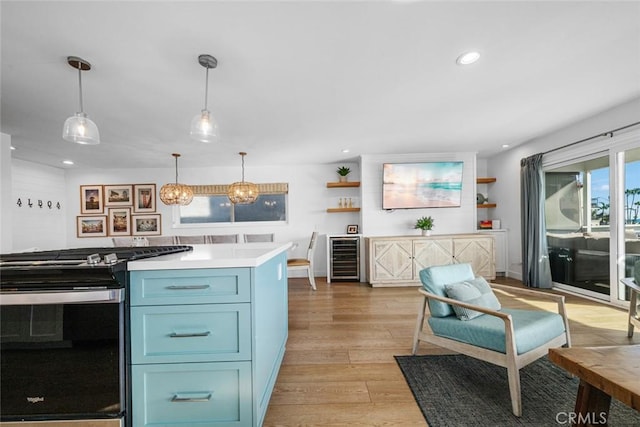 kitchen featuring blue cabinets, gas range, open shelves, light wood-type flooring, and wine cooler