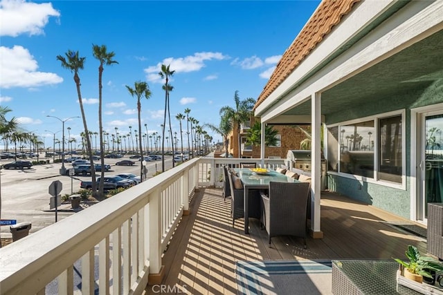 balcony with a grill and outdoor dining space