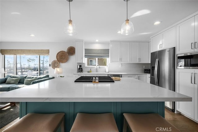 kitchen featuring appliances with stainless steel finishes, white cabinets, and a healthy amount of sunlight