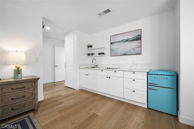 interior space featuring visible vents, open shelves, light countertops, light wood-style floors, and white cabinetry