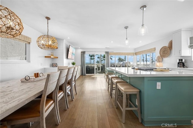 kitchen with a healthy amount of sunlight, light countertops, a spacious island, and hardwood / wood-style floors