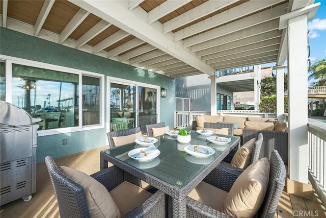 sunroom with an outdoor living space, outdoor dining area, and beam ceiling