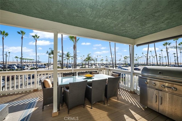 deck featuring a water view and outdoor dining area