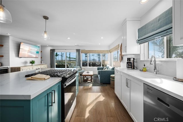 kitchen featuring stainless steel dishwasher, gas range oven, a wealth of natural light, and a sink