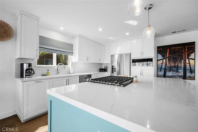 kitchen featuring visible vents, appliances with stainless steel finishes, wood finished floors, and white cabinets