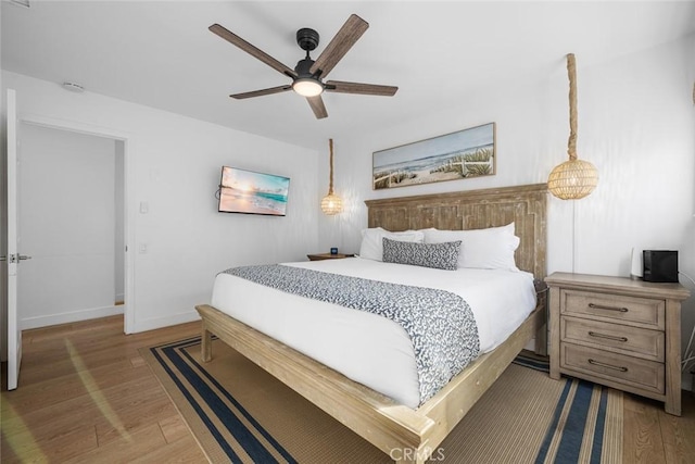 bedroom featuring baseboards, ceiling fan, and wood finished floors