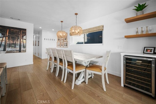 dining area with wood-type flooring, visible vents, beverage cooler, recessed lighting, and a dry bar