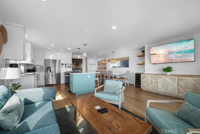 living room with recessed lighting, wine cooler, and light wood-style floors