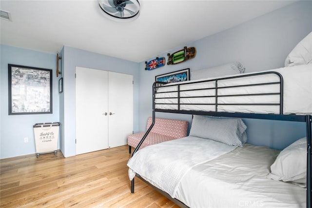 bedroom featuring a closet, light wood finished floors, and visible vents