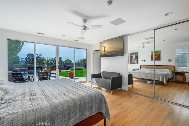 bedroom with access to outside, a ceiling fan, multiple windows, and light wood-style flooring