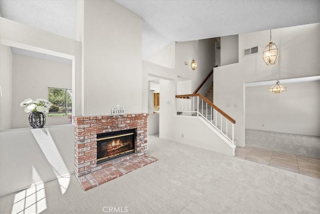 41880 Humber Dr, Temecula, CA 92591 - unfurnished living room featuring carpet floors, stairway, a brick fireplace, tile patterned floors, and high vaulted ceiling