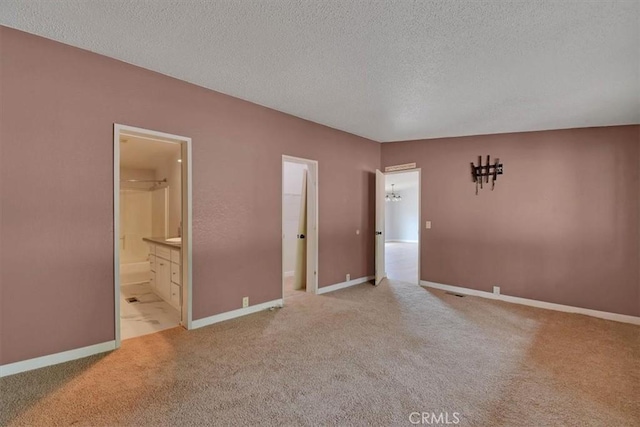 empty room with baseboards, carpet, and a textured ceiling
