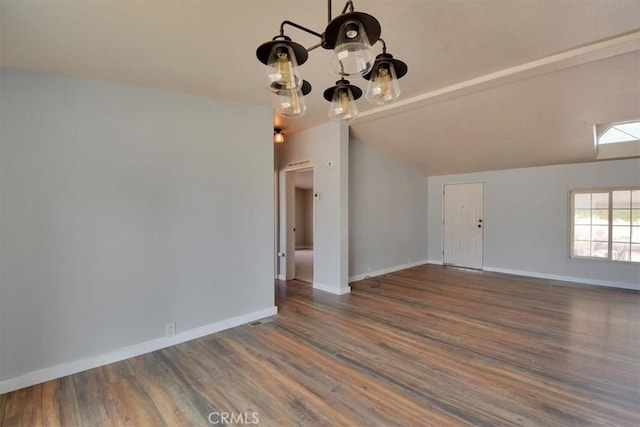 interior space with baseboards, a chandelier, and wood finished floors