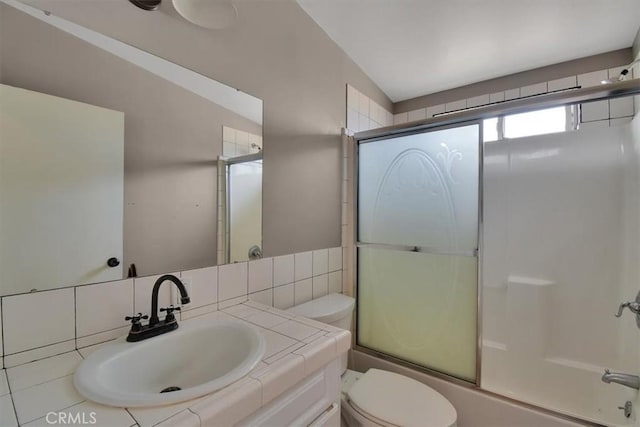 full bathroom featuring vanity, enclosed tub / shower combo, and toilet