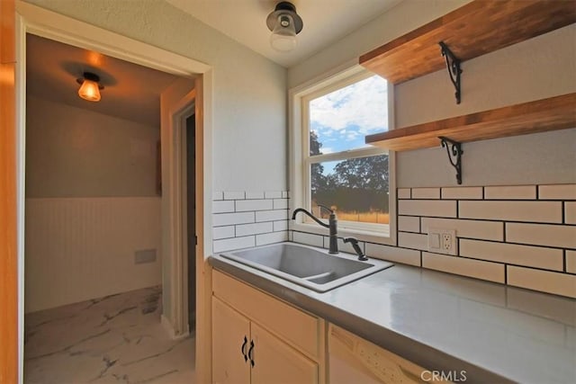 kitchen featuring white dishwasher, open shelves, a sink, marble finish floor, and backsplash
