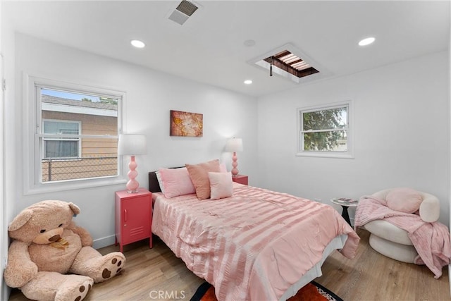 bedroom featuring multiple windows, light wood-style flooring, and visible vents