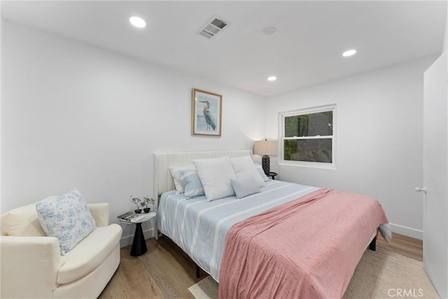 bedroom with recessed lighting, baseboards, visible vents, and wood finished floors