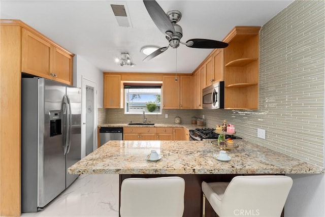 kitchen with a peninsula, a sink, stainless steel appliances, visible vents, and marble finish floor