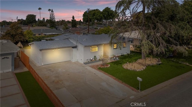 single story home featuring concrete driveway, a yard, stucco siding, and a garage