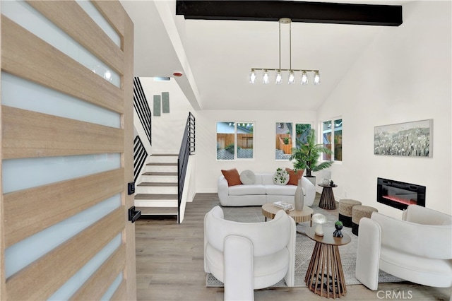 29282 Sonoma Way, San Juan Capistrano, CA 92675 - living room featuring high vaulted ceiling, a chandelier, a glass covered fireplace, wood finished floors, and stairway