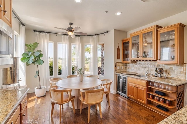 dining space featuring recessed lighting, wet bar, dark wood-type flooring, and wine cooler