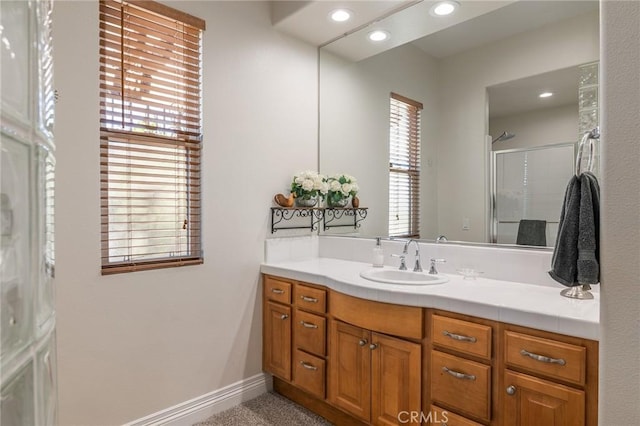 full bath with an enclosed shower, vanity, baseboards, and recessed lighting