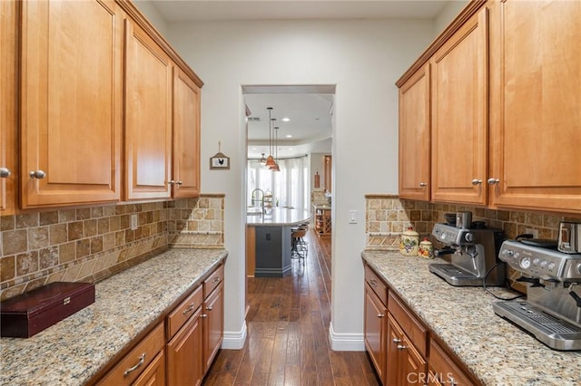 kitchen featuring recessed lighting, light stone counters, tasteful backsplash, and dark wood-style flooring