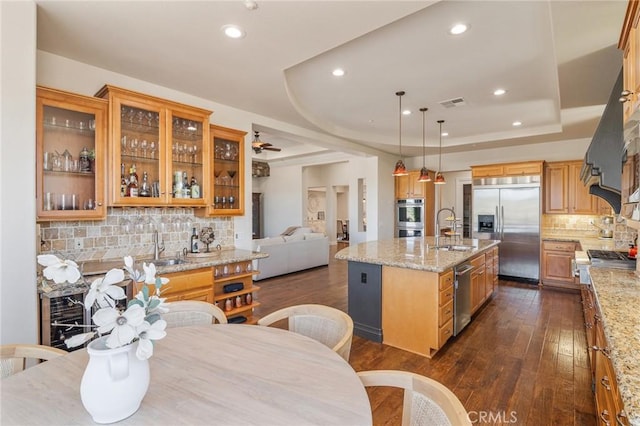 3863 Flowerwood Ln, Fallbrook, CA 92028 - kitchen with appliances with stainless steel finishes, decorative backsplash, dark wood finished floors, a kitchen island with sink, and recessed lighting