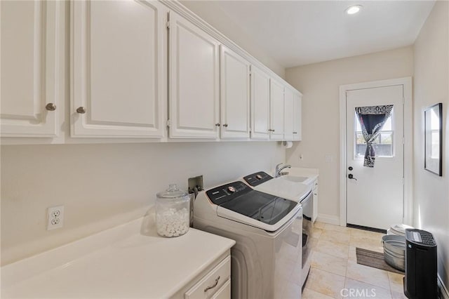 laundry room featuring baseboards, a sink, cabinet space, and independent washer and dryer