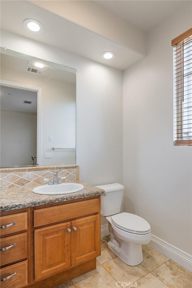 bathroom featuring toilet, baseboards, visible vents, and vanity
