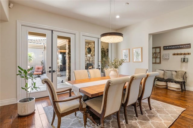 dining room featuring wood-type flooring, baseboards, and french doors