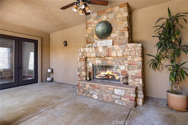 view of patio featuring ceiling fan, french doors, and a stone fireplace