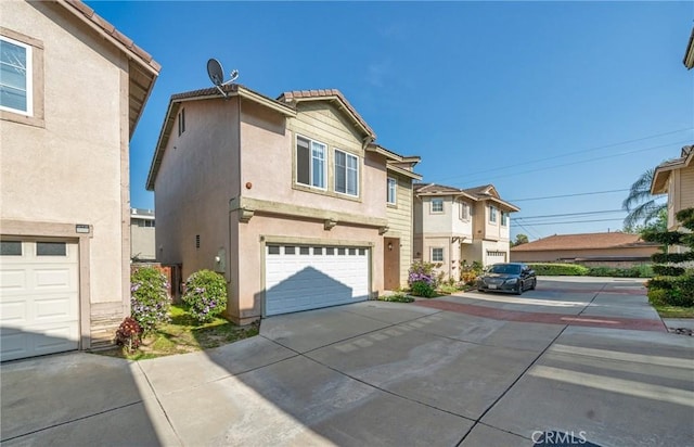 view of front of home featuring a garage, stucco siding, a residential view, and concrete driveway