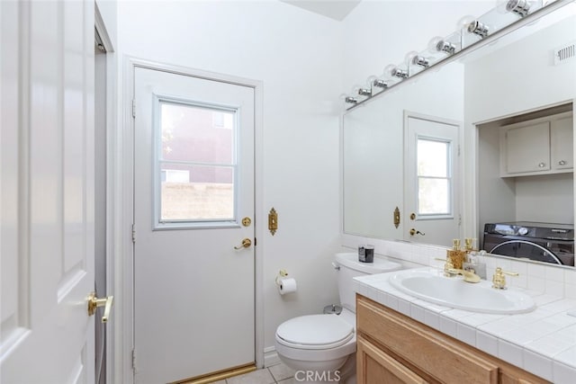bathroom featuring washer / clothes dryer, toilet, tile patterned floors, and vanity
