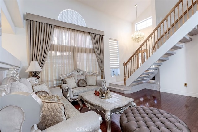 living room featuring wood-type flooring, high vaulted ceiling, a chandelier, stairs, and baseboards
